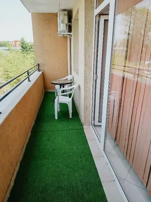 a balcony with green flooring in a building at Kamelia Garden Apartment in Sunny Beach