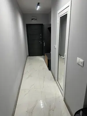 a hallway with a door and a tile floor at Апартамент - Весела улица in Sozopol