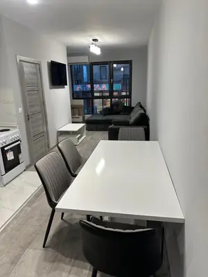 a living room with a white table and chairs at Апартамент - Весела улица in Sozopol