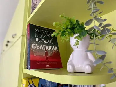 a shelf with two books and a vase with a plant at JOY Studio in Ravda