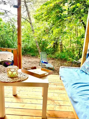 a patio with a table and a couch on a deck at Каравана Синята Маймуна плаж Градина # RV Blue Monkey on the beach in Chernomorets