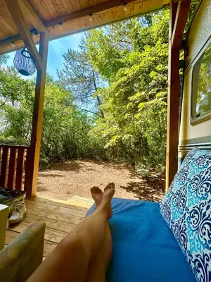 a baby laying on a bed on a porch at Каравана Синята Маймуна плаж Градина # RV Blue Monkey on the beach in Chernomorets