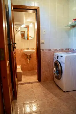 a bathroom with a washing machine and a sink at Къща за гости Далинда in Byala
