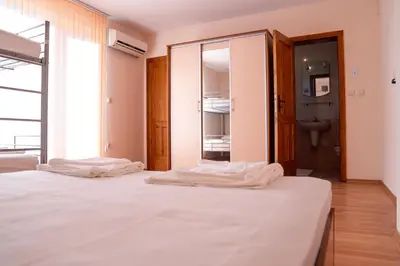 a bedroom with two white beds and a bathroom at Къща за гости Далинда in Byala