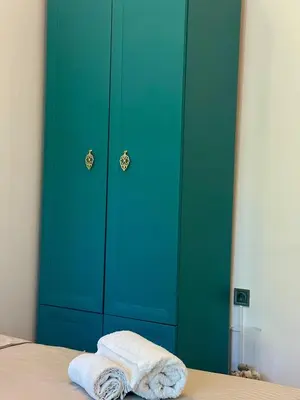 a green closet with a towel sitting on a bed at Varna city Park Apartament in Varna City
