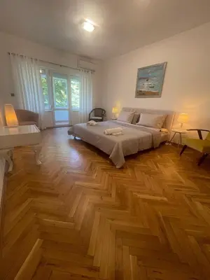 a bedroom with a bed and a wooden floor at Varna city Park Apartament in Varna City