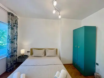 a bedroom with a bed and a green cabinet at Varna city Park Apartament in Varna City