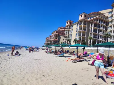 a group of people on a beach with umbrellas at Elenite Sea View Apartments in Elenite