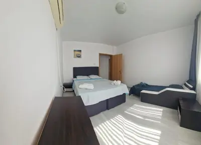 a hotel room with two beds and a couch at Апартамент Бижу М in Pomorie