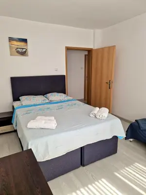 a bedroom with a bed with two towels on it at Апартамент Бижу М in Pomorie