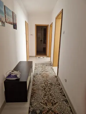 a hallway with a black table and a rug at Апартамент Бижу М in Pomorie