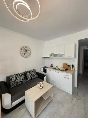 a living room with a couch and a table at Прекрасно студио in Sunny Beach