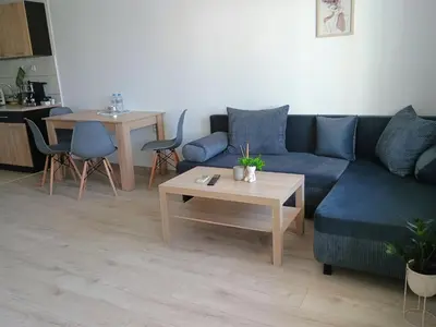 a living room with a blue couch and a table at Васил Левски 61 in Burgas City