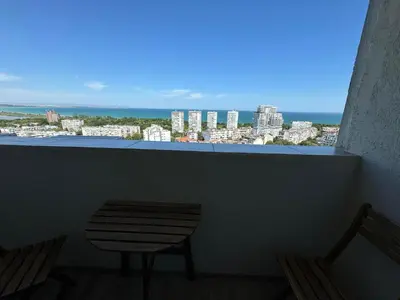a balcony with a table and a view of a city at Апартамент Панорама Лазур in Burgas City