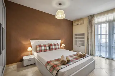 a bedroom with a bed with two pairs of shoes on it at 2BD Flat with Balcony in Flores Garden Complex by Flat Mаnаger in Chernomorets
