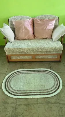 a couch with pillows and a rug on the floor at Aurora Sea Breeze in Burgas City