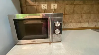 a microwave oven sitting on the floor in a room at Aurora Sea Breeze in Burgas City