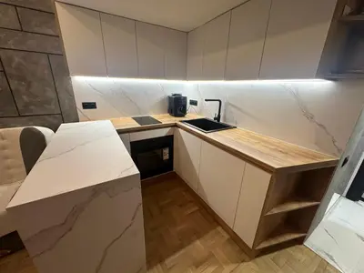 a small kitchen with white cabinets and a counter top at Studio Lazur in Burgas City