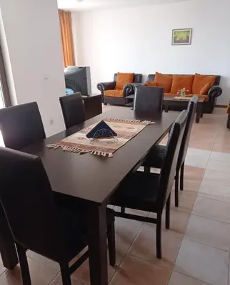 a dining room with a table and chairs at Апартамент Къмпинг Градина in Chernomorets