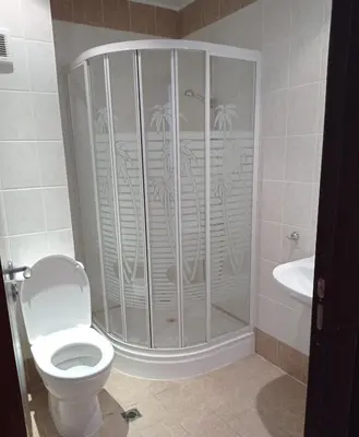 a bathroom with a shower with a toilet and a sink at Апартамент Къмпинг Градина in Chernomorets