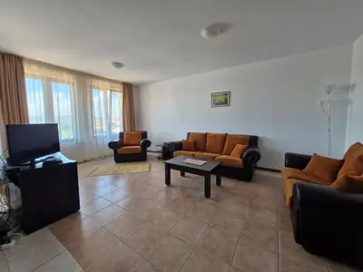 a living room with couches and a flat screen tv at Апартамент Къмпинг Градина in Chernomorets