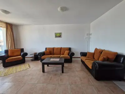a living room with two couches and a coffee table at Апартамент Къмпинг Градина in Chernomorets