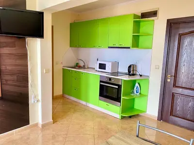 a green kitchen with green cabinets and a microwave at DELFIN Sea view in Sveti Vlas
