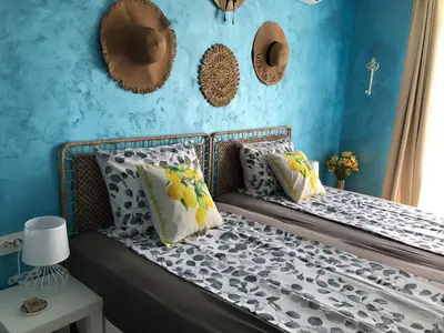 a bedroom with blue walls and a bed with pillows at Студио - Морско бягство in Primorsko