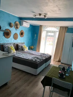 a bedroom with a large bed with a blue wall at Студио - Морско бягство in Primorsko