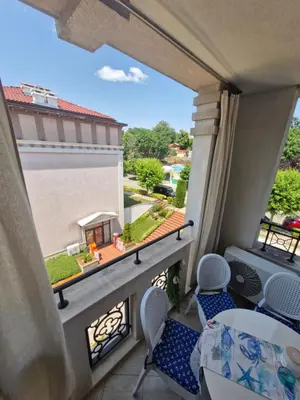 a balcony with chairs and a view of a yard at Студио в Затворен Комплекс Blue in Sozopol