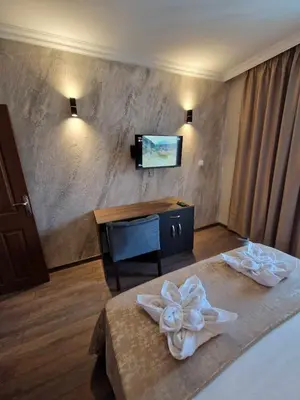 a hotel room with a bed and a tv on the wall at MitProt Panorama Bay 2 Luks Apartment 110 in Sveti Vlas