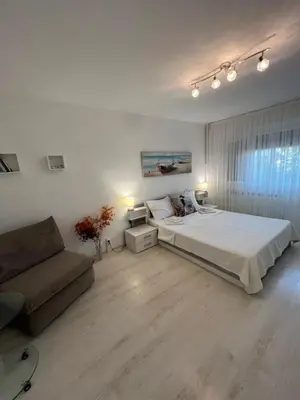 a white bedroom with a bed and a couch at Tei-Zi apartments2 in Burgas City