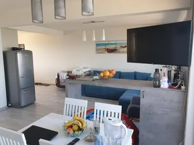 a living room with a table and chairs and a television at Solar Rise apartment in Pomorie