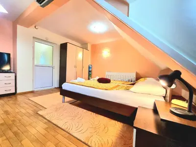 a bedroom with a large bed with a staircase at Two-Floor Sunny Apartment in City Centre in Burgas City