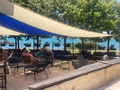 a group of people sitting in chairs under umbrellas at Marina Cape Sky View Lux Apartment in Aheloy in Aheloy