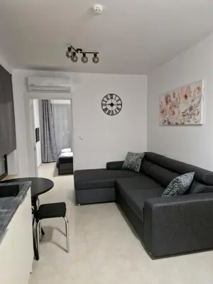 a living room with a couch and a clock on the wall at Polarstar 205A am Meer Sveti Vlas in Sveti Vlas