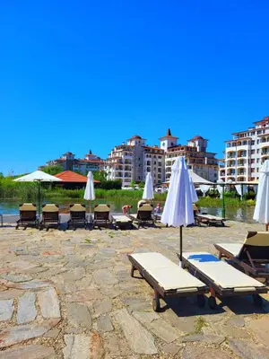 a group of lounge chairs and umbrellas on a beach at Apartment Sunrise in Obzor