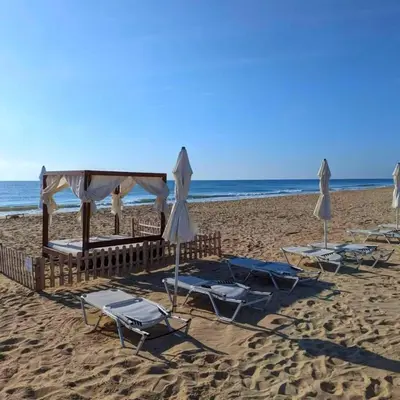 a group of chairs and umbrellas on a beach at Apartment Sunrise in Obzor