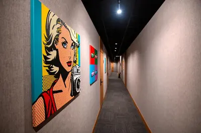 a hallway with paintings of a woman on the wall at Smart Rooms in Varna City