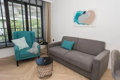 a living room with a couch and a chair at KASHMIR Deluxe apartment with Parking in Burgas City