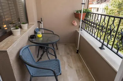 a balcony with a table and chairs and a window at KASHMIR Deluxe apartment with Parking in Burgas City