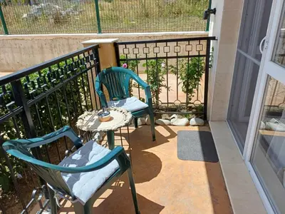 two chairs and a table on a balcony at Sunny holidays in Byala