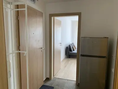 a room with a refrigerator and a hallway with a couch at Sunny holidays in Byala