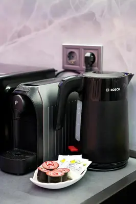 a coffee pot and a plate of cupcakes on a counter at Deluxe 3 Studio City Center in Burgas City