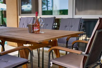 a wooden table with a bottle and glasses on it at Paradise villas in Sozopol
