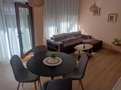 a living room with a couch and a table and chairs at Апартамент РАЯ in Sozopol