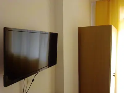 a flat screen tv hanging on a wall at Guest House Malkata Stopanka in Primorsko