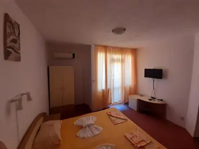 a small bedroom with a bed and a window at Guest House Malkata Stopanka in Primorsko