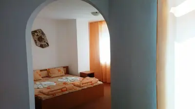 a bedroom with a bed and an arched doorway at Guest House Malkata Stopanka in Primorsko