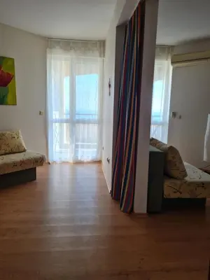 a living room with a couch and a large window at Entire apartment 4pax , sea view, pool in Ravda